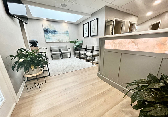 The image shows an interior view of a dental clinic reception area, featuring a sign that reads  HOFFER DENTAL CARE  and a reception desk with a countertop.