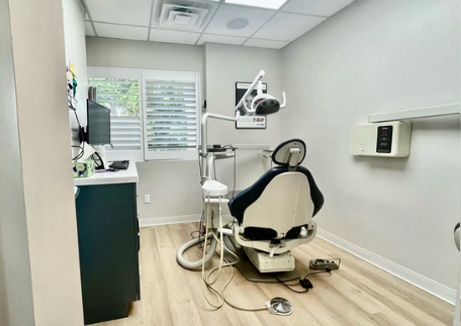 An interior view of a dental office with a dentist s chair, equipment, and a reception area.