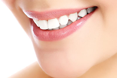 A close-up of a person s face, featuring a radiant smile and healthy teeth, with an emphasis on dental care or oral hygiene.