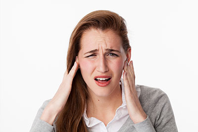 Woman with hand on head, expressing discomfort or concern.