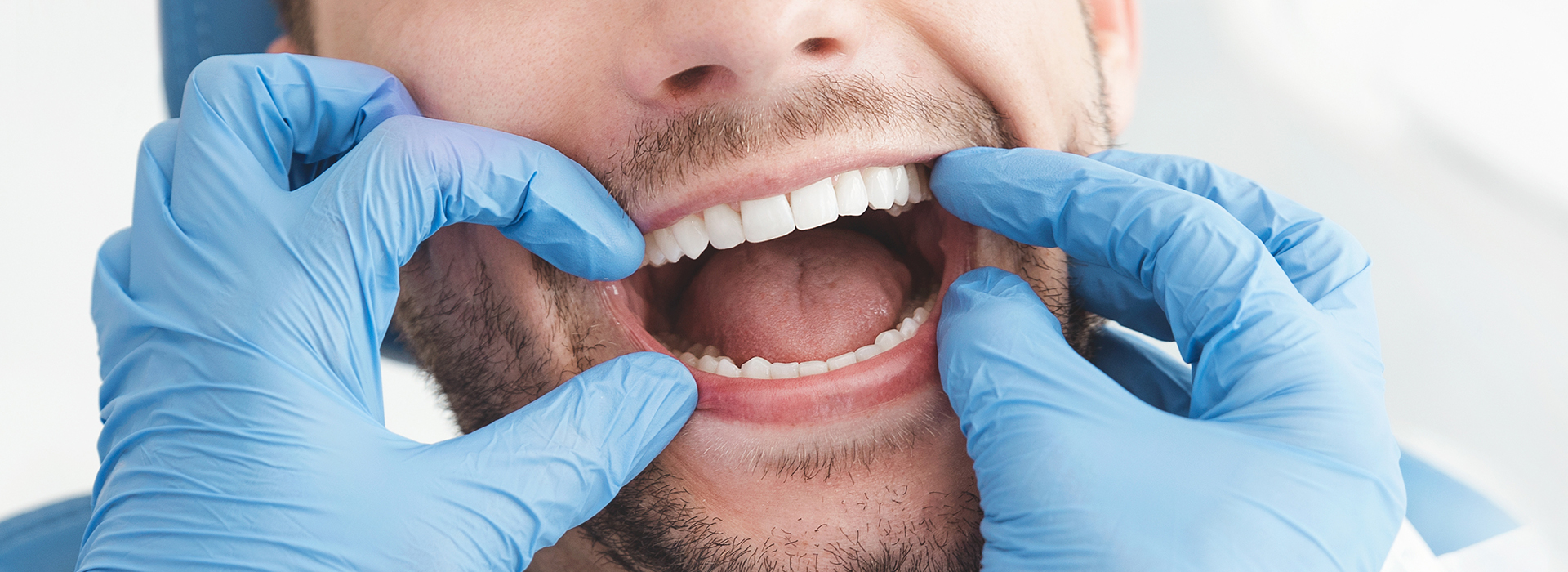 A dentist with a patient s mouth open, performing a dental procedure.